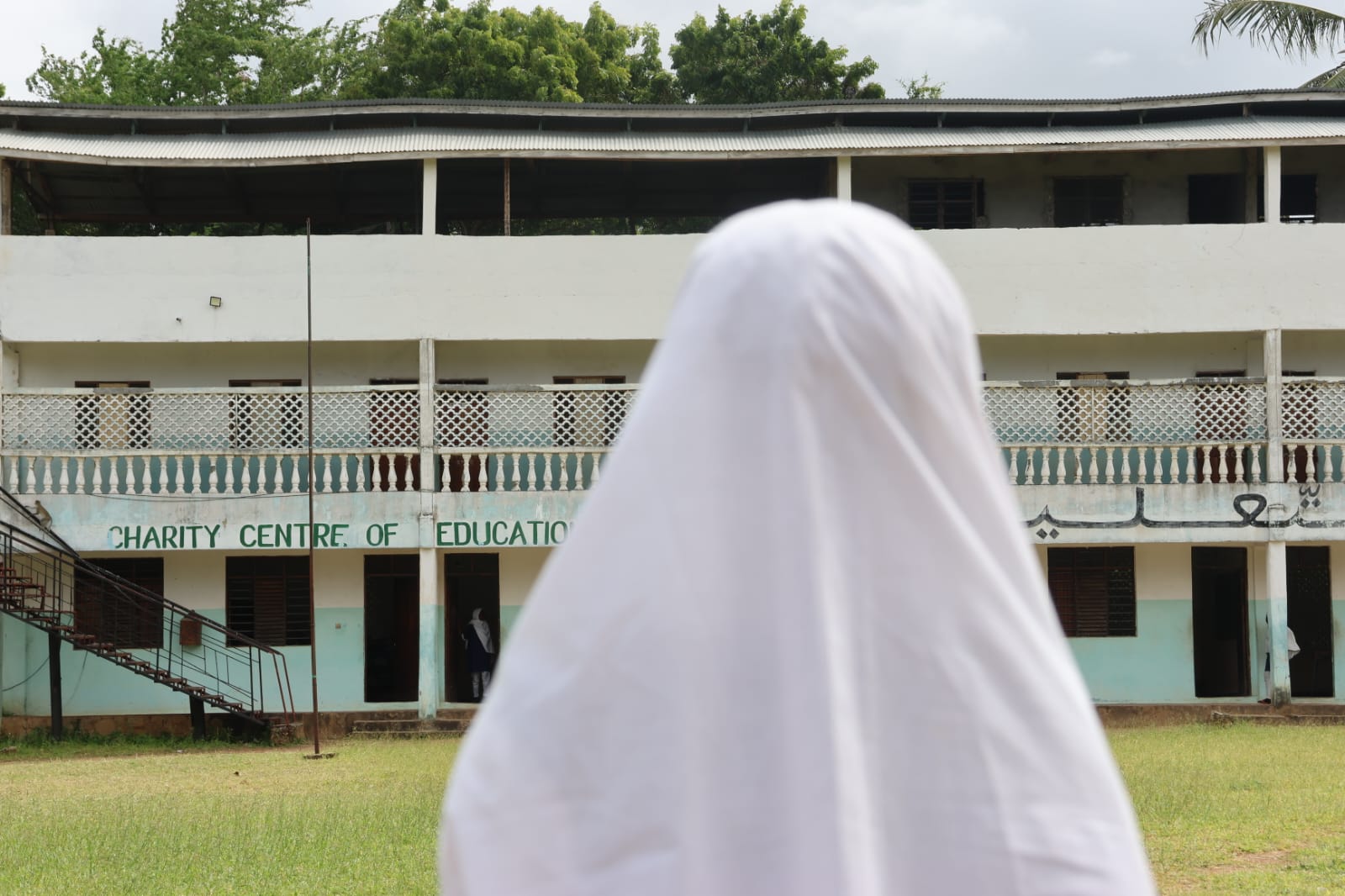 A girl in a white hijab standing in front of the charity centre